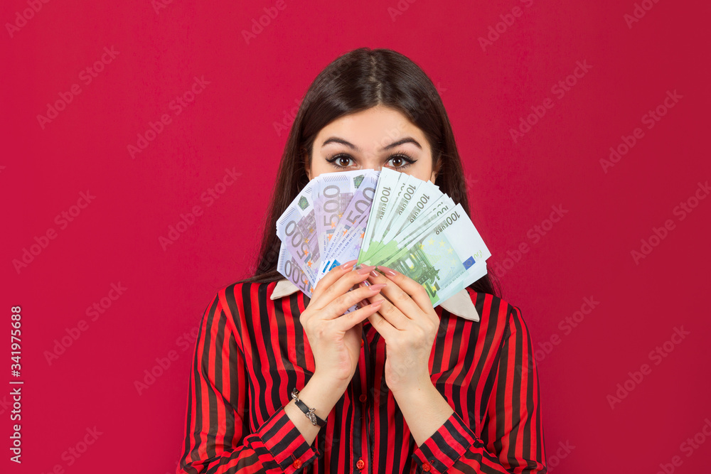 beautiful young woman with euro in hands on a red background
beautiful young woman with euro in hands on a red background