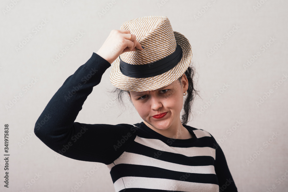 Woman takes off his hat and clothes. Gray background. Woman takes off his hat and clothes. Gray background.