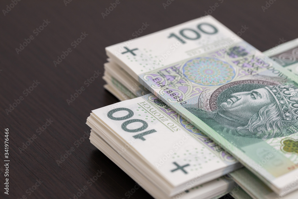 Banknotes evenly distributed on a dark brown desk ready for use. Banknotes evenly distributed on a dark brown desk ready for use.