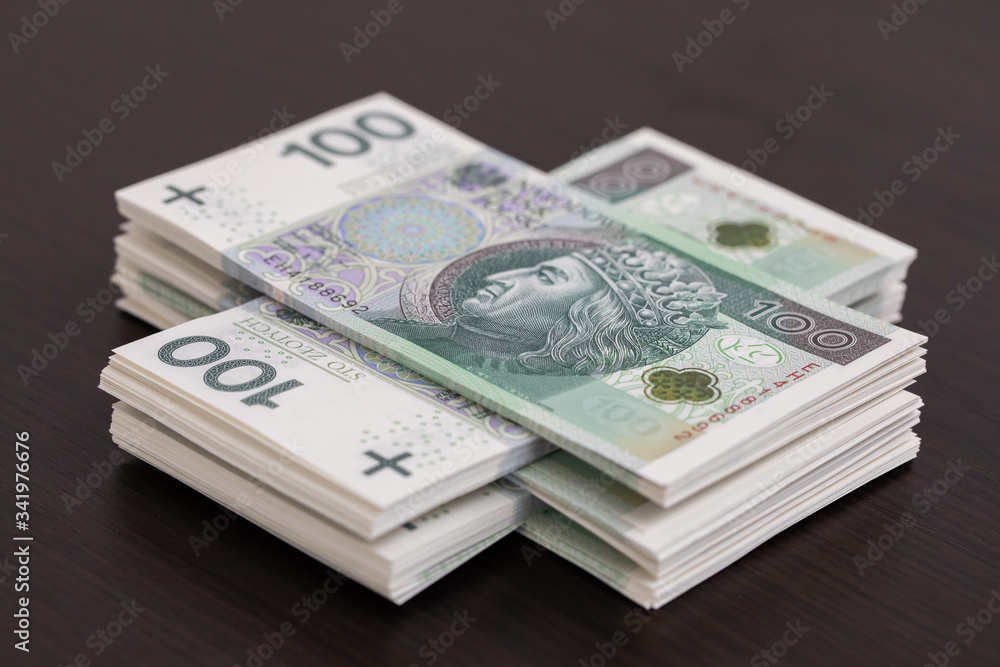 Banknotes evenly distributed on a dark brown desk ready for use. Banknotes evenly distributed on a dark brown desk ready for use.
