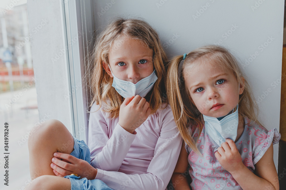 blond girls do not want to get sick do not want to wear masks against coronovirus. children want to go outside covid