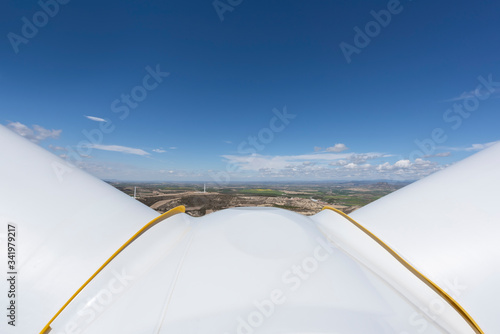 View from background windmills for the production of electrical energy. Clean energy  blue sky.