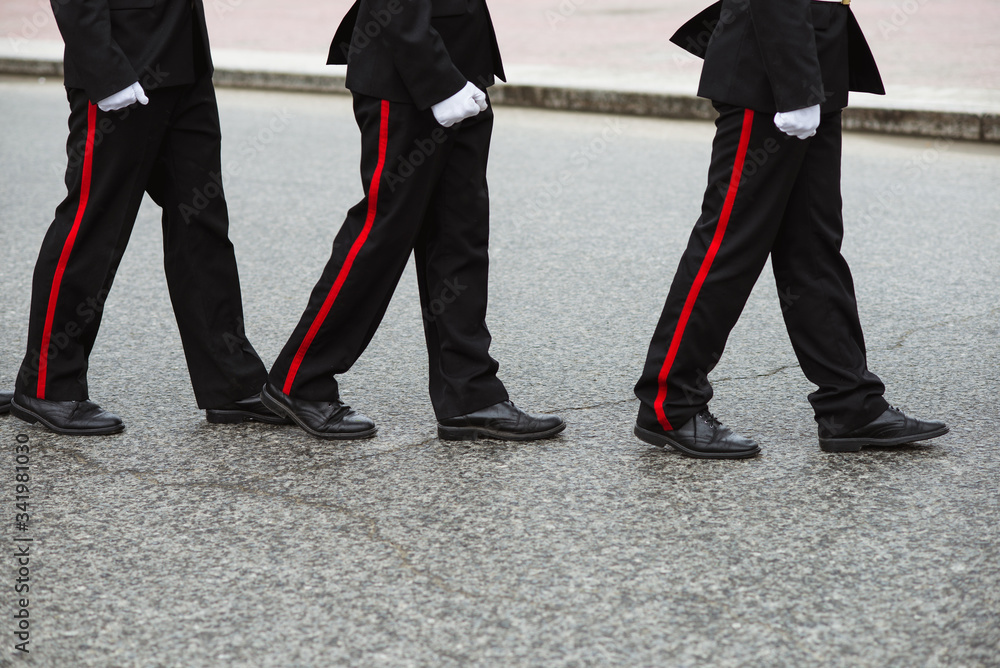 Three Russian cadets in a ceremonial black uniform go one after another. Crop by waist. People in uniform Three Russian cadets in a ceremonial black uniform go one after another. Crop by waist. People in uniform
