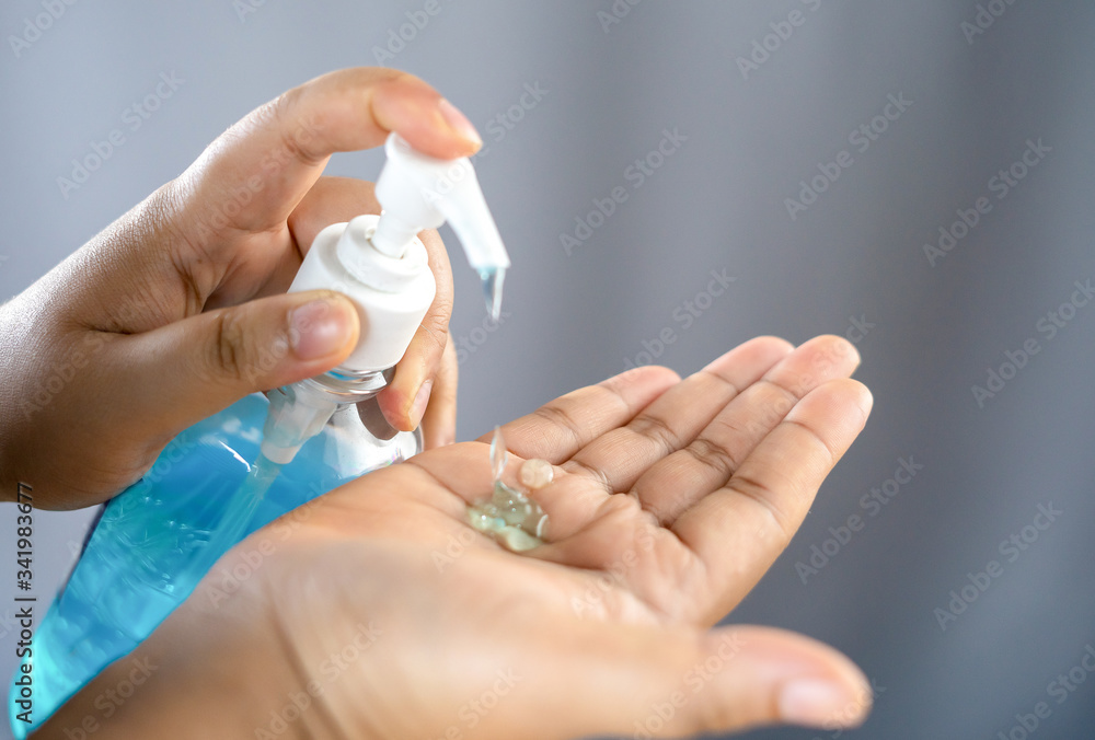 COVID-19 Close up woman hands using wash hand sanitizer gel dispenser, against Novel coronavirus (2019-nCoV) at home. Home isolation, Auto Quarantine, Antiseptic, Hygiene and Healthcare concept. COVID-19 Close up woman hands using wash hand sanitizer gel dispenser, against Novel coronavirus (2019-nCoV) at home. Home isolation, Auto Quarantine, Antiseptic, Hygiene and Healthcare concept.