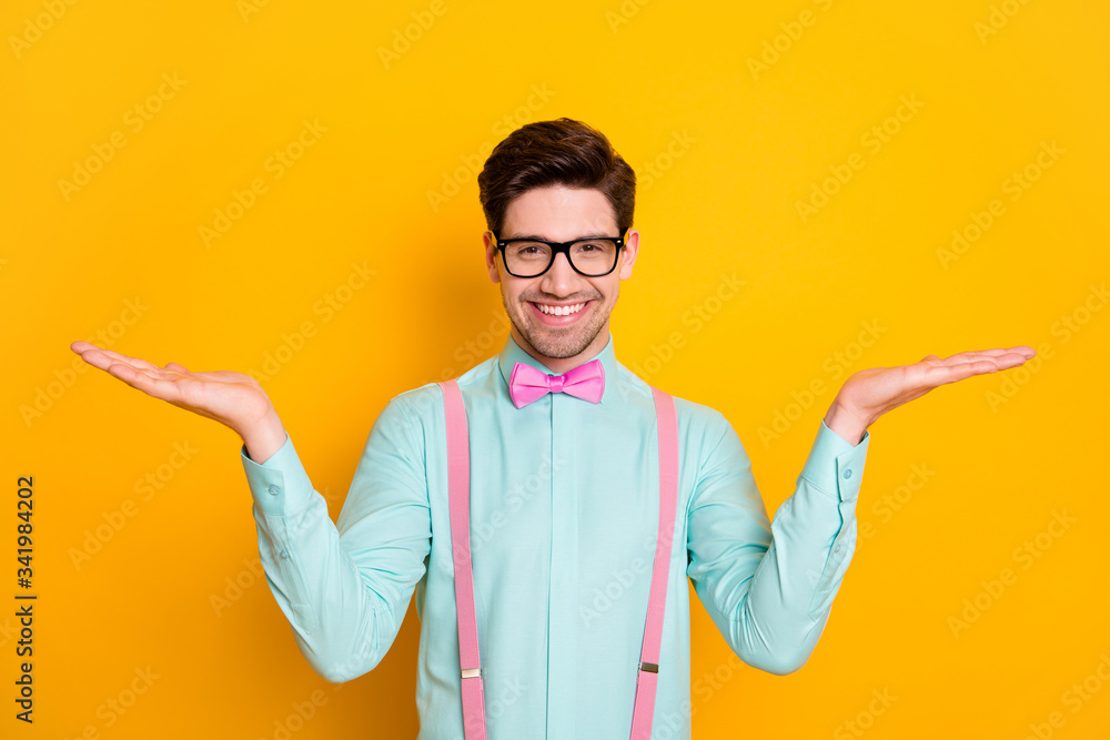 Portrait of positive cheerful guy hold hand demonstrate ads promo feedback recommend suggest select wear good look clothes isolated over shine color background
