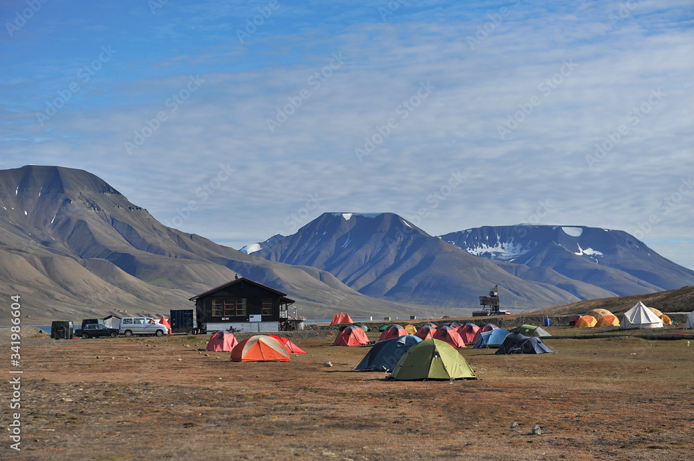 Camp of tourist tents on the island of Svalbard. Thousands of tourists come to Svalbard and discover the beauty of the polar north.