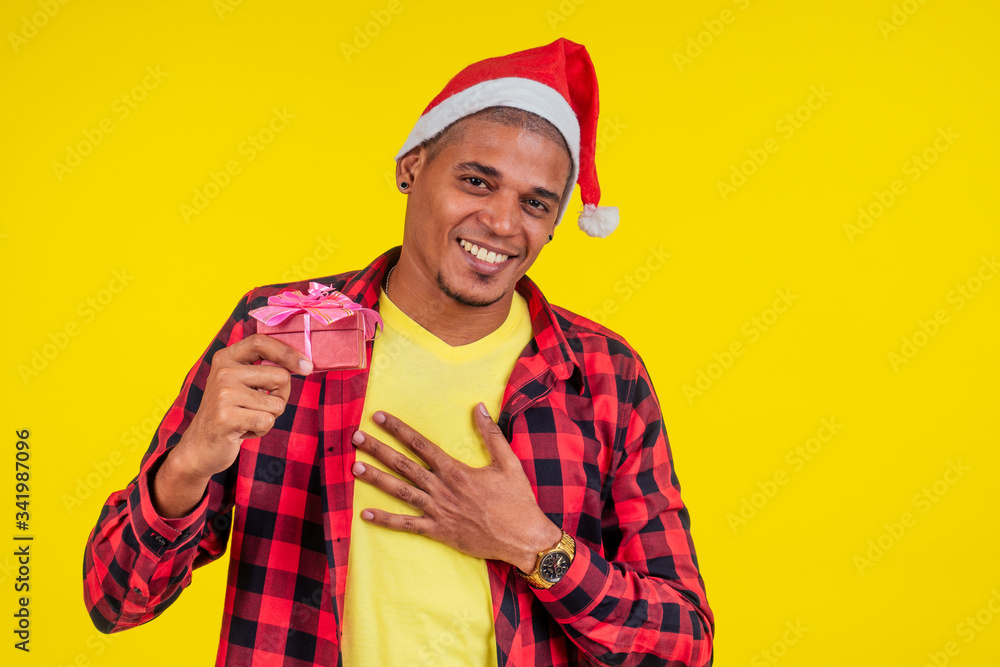 latin hispanic santa men showing gifts box in yellow wall studio