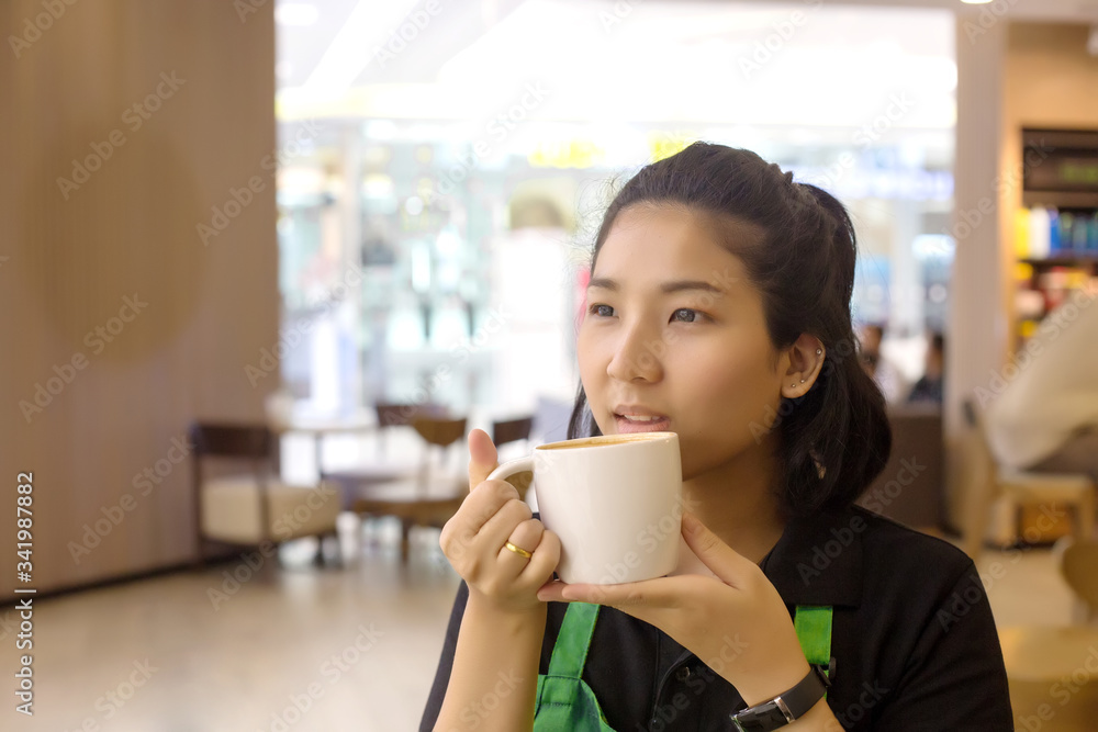 asian woman barista holding coffee cup to test and drinking at cafe asian woman barista holding coffee cup to test and drinking at cafe
