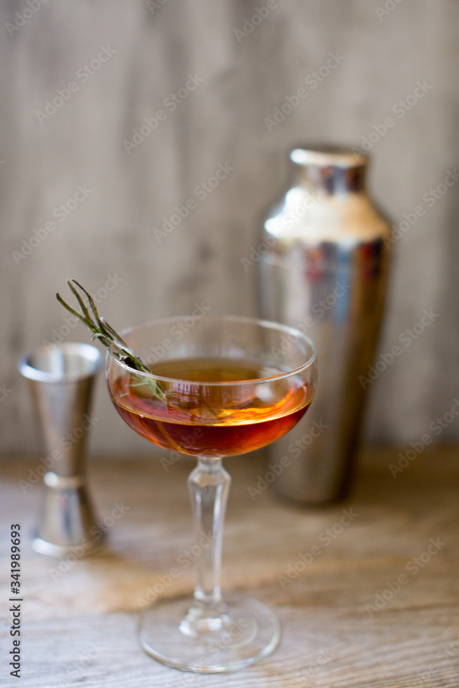 alcohol whiskey cocktail in a coupe glass with lemon and shaker alcohol whiskey cocktail in a coupe glass with lemon and shaker