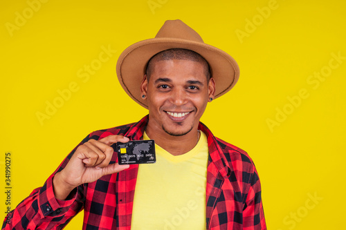 afro brazilian man with credit card in stusio on yellow background.farmer taking a loan in a bank for small business in agriculture