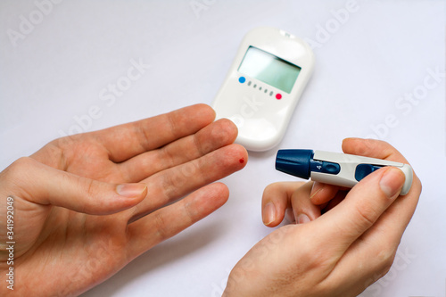 Close-up photo with man who testing his level of glucose in his blood with blood glucose meter