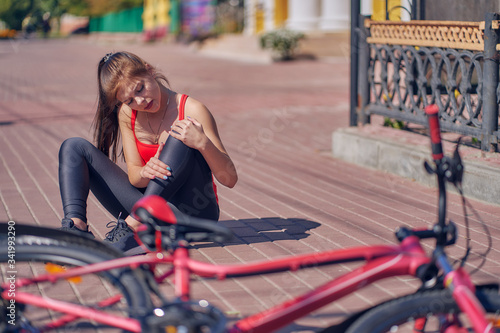 girl fell off the bicycle. injury, damage, city traffic, learn to cycling