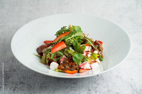 Salad with warm chicken liver, fresh strawberries and vegetables