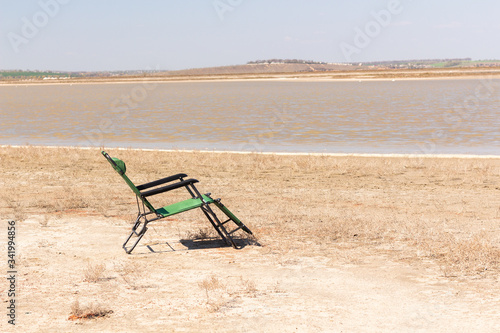 empty deck chair on the promenade, deck chair on the sandy beach