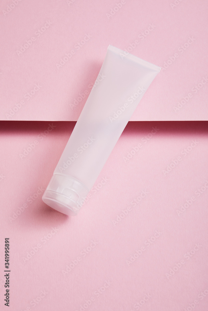 High angle view of empty plastic cosmetic cream tube on pink background High angle view of empty plastic cosmetic cream tube on pink background