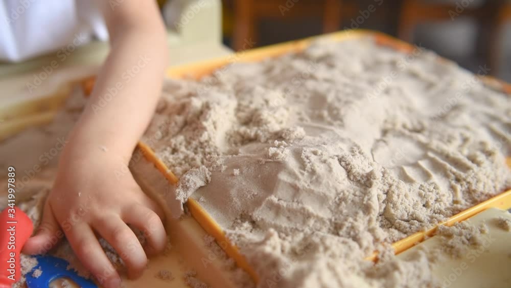 A child is quarantined at home and plays in the sandbox during the pandemic and Covid-19. Boy makes sand molds A child is quarantined at home and plays in the sandbox during the pandemic and Covid-19. Boy makes sand molds
