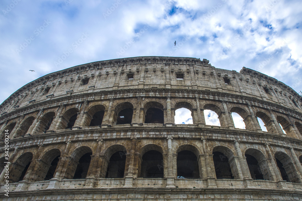 Colosseum in Rome, Italy. Ancient Roman Colosseum is one of the main tourist attractions in Europe. People visit the famous Colosseum in Roma center. Scenic view of Colosseum ruins.
