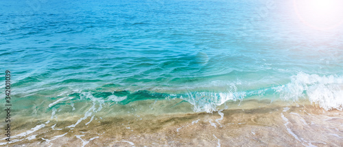 Banner sized background texture of clear, turquoise ocean waves