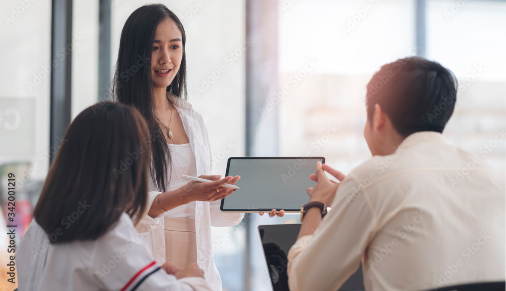 young busineswoman using tablet persenting business plan with her team in office. young busineswoman using tablet persenting business plan with her team in office.