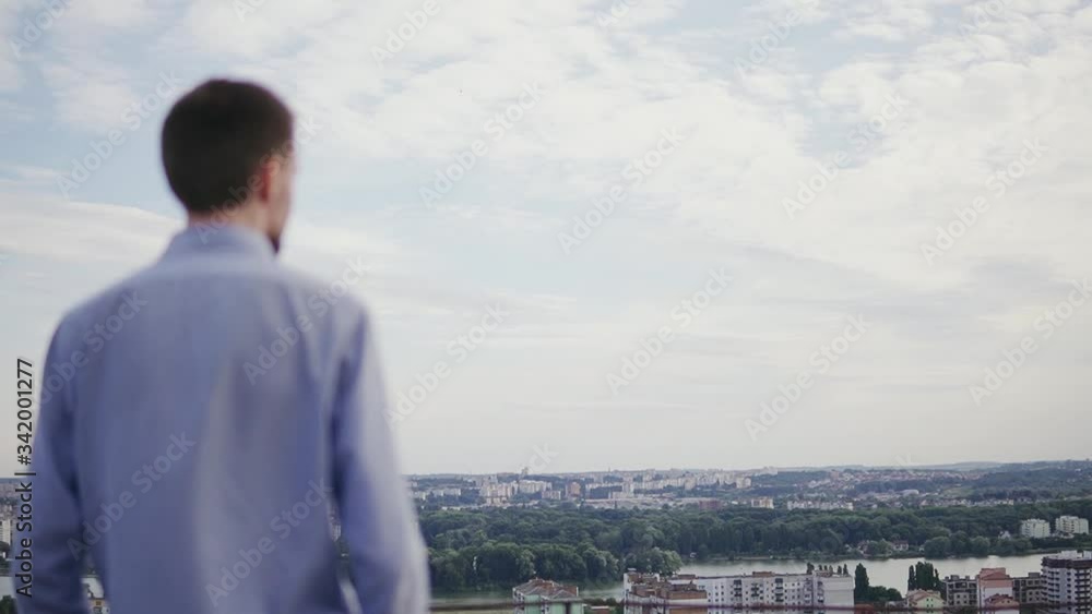 Man tourist meditatively looking at the beautiful landscape overlooking the city Man tourist meditatively looking at the beautiful landscape overlooking the city