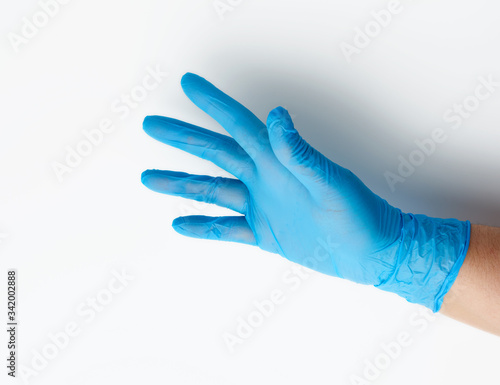 blue medical glove is worn on the arm, part of the body on a white background