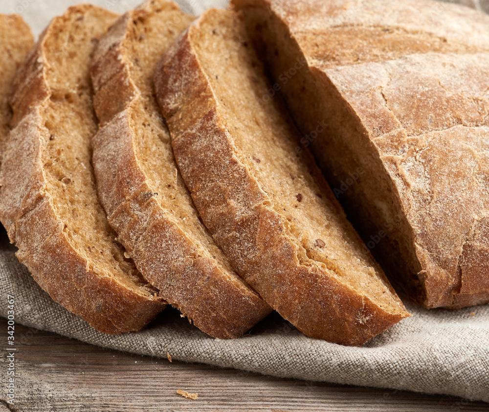 sliced round baked rye flour bread on a gray linen napkin