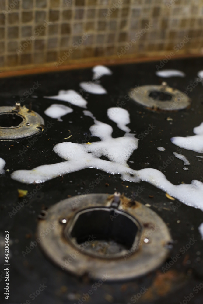 Old dirty gas stove/oven with ugly sticky residue on black glass