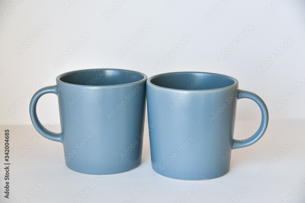 two coffee cups on a white table in a bright kitchen two coffee cups on a white table in a bright kitchen