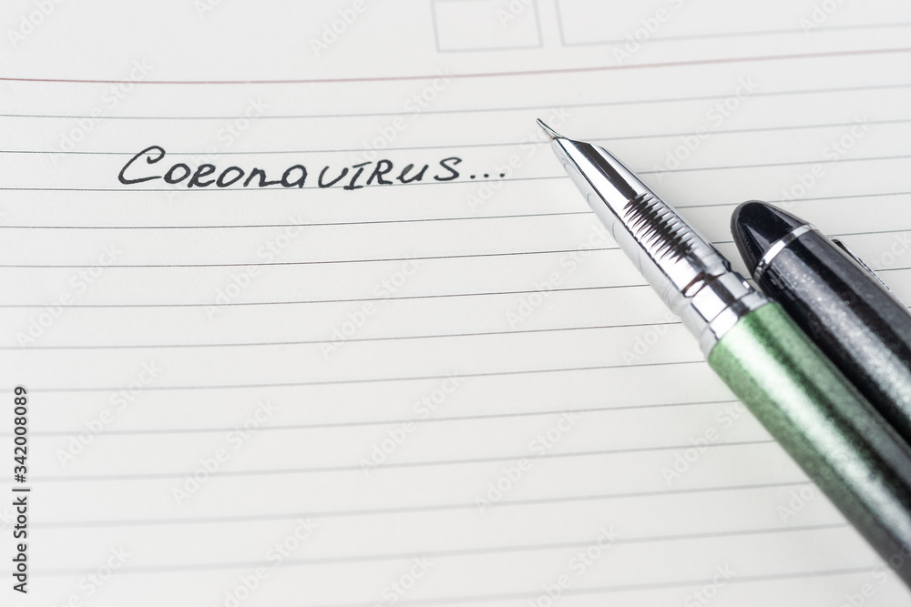 Coronavirus Covid-19 text hand-written on empty sheet in a daily planner. Coronavirus Covid-19 text hand-written on empty sheet in a daily planner.