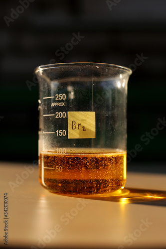 The formation of red liquid bromine in a beaker with a volume of 250 milliliters.