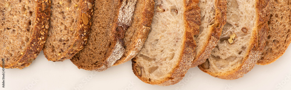 top view of fresh whole wheat bread slices on white background, panoramic shot