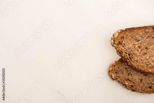 top view of fresh brown bread slices on white background