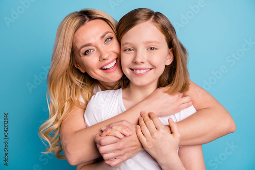 Closeup photo of two people beautiful mom lady little daughter hugging best friends piggyback holding arms spend time together wear casual white s-shirts isolated blue color background photo