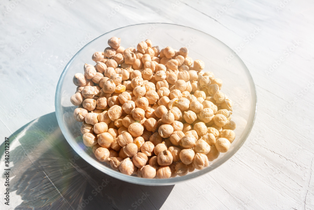 chickpea in a glass bowl on a grey table top view natural sunlight and hard shadow. Healthy dietary food concept
chickpea in a glass bowl on a grey table top view natural sunlight and hard shadow. Healthy dietary food concept