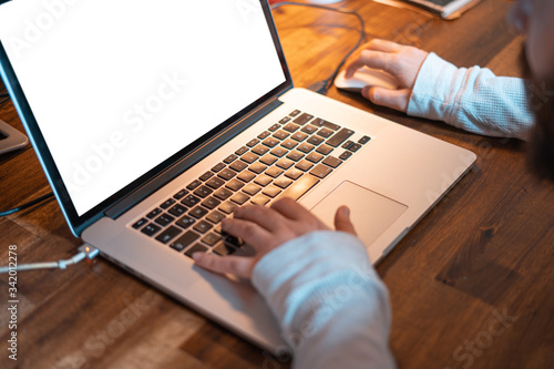 Hands pictured on the keyboard of a laptop typing something. 