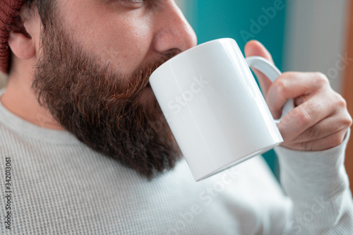 young designer with hipster style beard drinking coffee