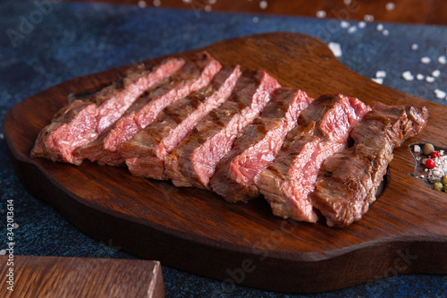 Ready striploin steak on a wooden panel.