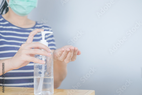 Wallpaper Mural Closeup Asian woman wearing protective mask using hand sanitizer by pumping alcohol gel. Cleaning her hands with sanitizer gel. in quarantine for coronavirus wearing protective mask Hygiene concept. Torontodigital.ca