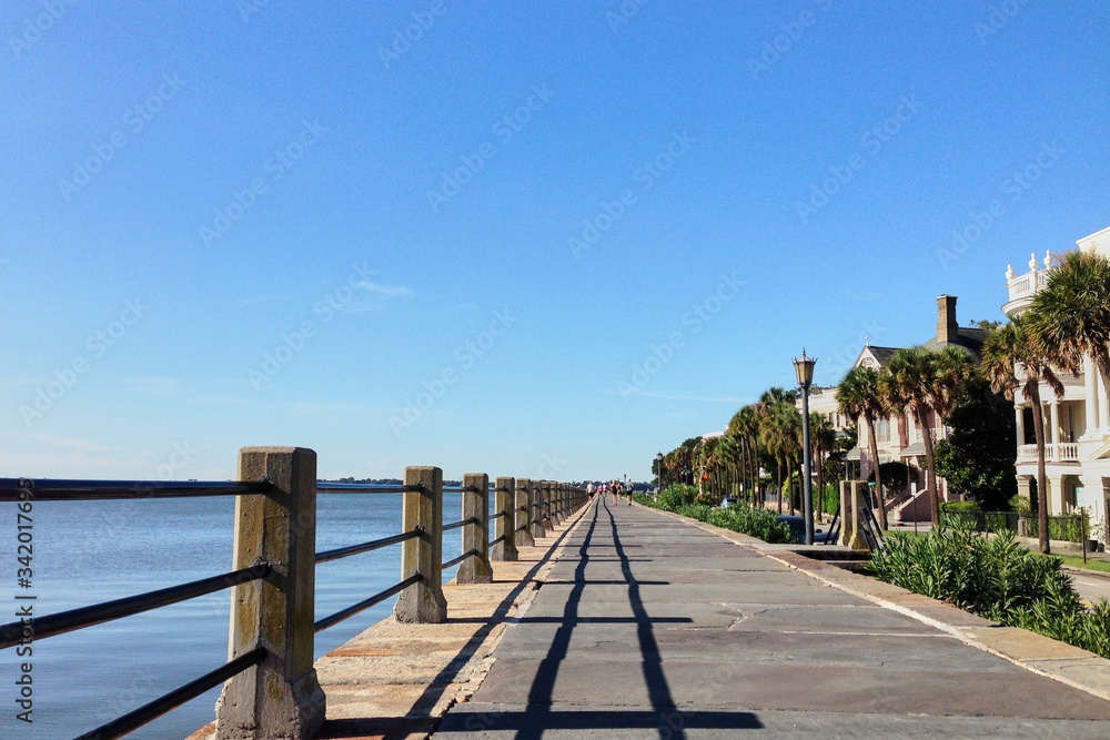 Charleston, South Carolina/USA - Sep 03, 2016: Boardwalk with houses on one side and sea on the other side in Charleston port. Sunny view at the Charleston bay.