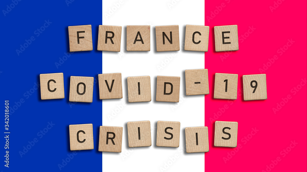 France Covid 19 crisis written with wooden tiles over French flag background France Covid 19 crisis written with wooden tiles over French flag background