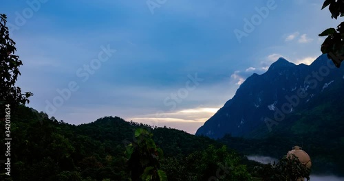 Time lapse Landscape Sunrise with mountain, hill with trees, blue sky with mist.