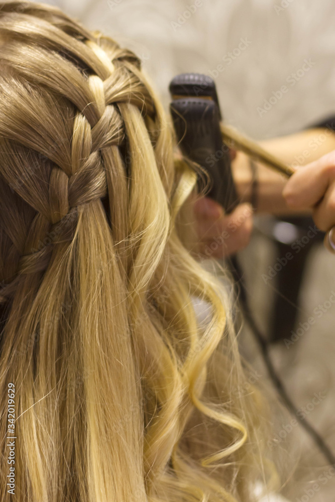 Fototapeta premium Long blonde hair being braided plaited into an intricate hairstyle