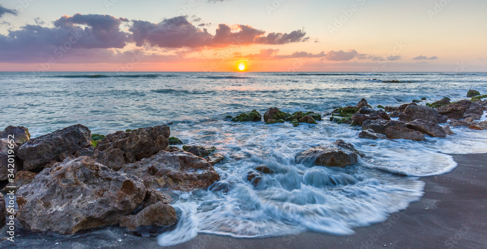 Sunset over the rocky shore of the Gulf of Mexico at Caspersen Beach in Venice Florida