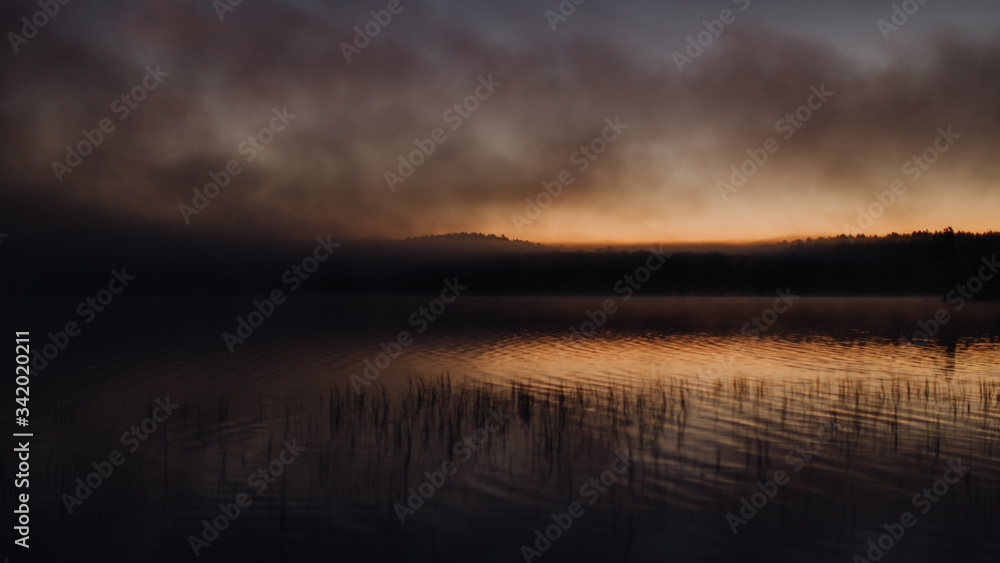 Lever de soleil nuageux sur le lac 