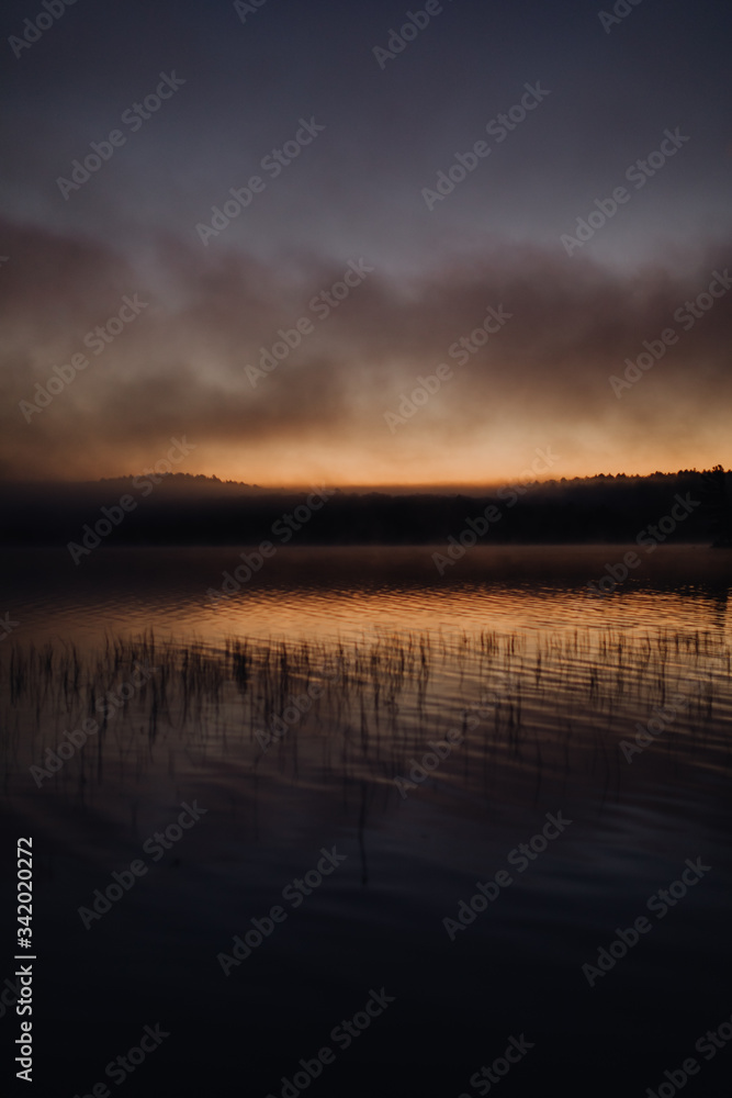 Lever de soleil nuageux sur le lac 