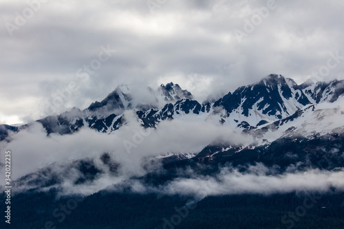 Snow capped rugged rocky mountains in clouds on the Kenai Peninsula of Alaska