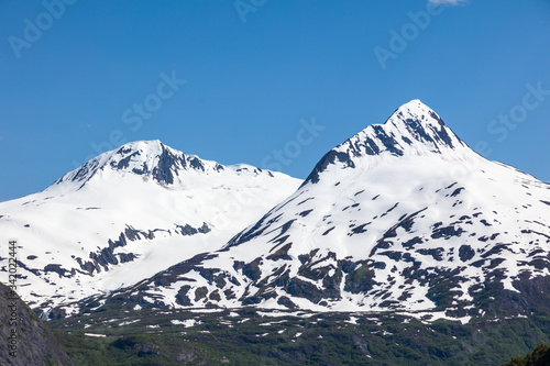 Snow capped rugged rocky mountains on blue sky day on the Kenai Peninsula of Alaska © Jim Schwabel