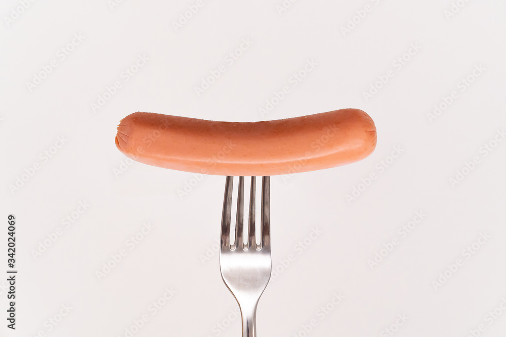 Raw frankfurter sausage on a fork isolated Raw frankfurter sausage on a fork isolated