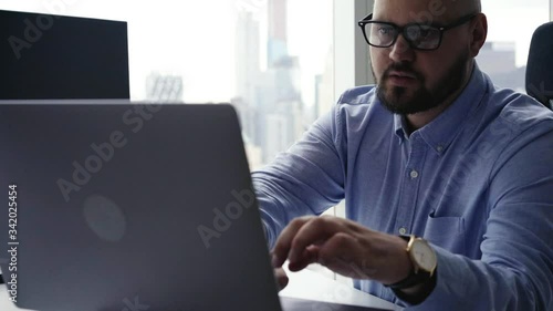 Overjoyed male broker celebrating online results of money investitions excited with approved rake-off on financial website,accomplished businessman in optical spectacles using technology for marketing photo