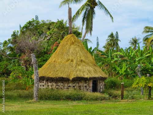 Typical Kanak house in New Caledonia with sculptures from the life of the local people.